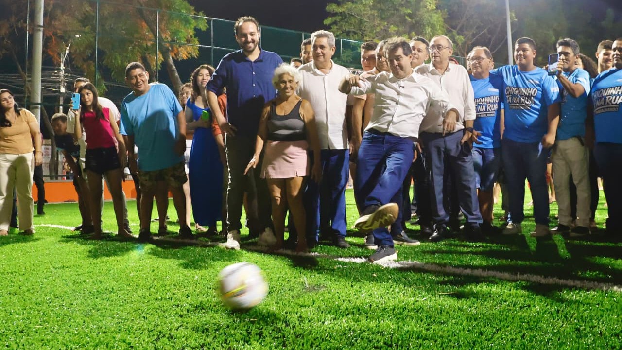 prefeito evandro chutando a bola na marca do pênalti no campo da na areninha